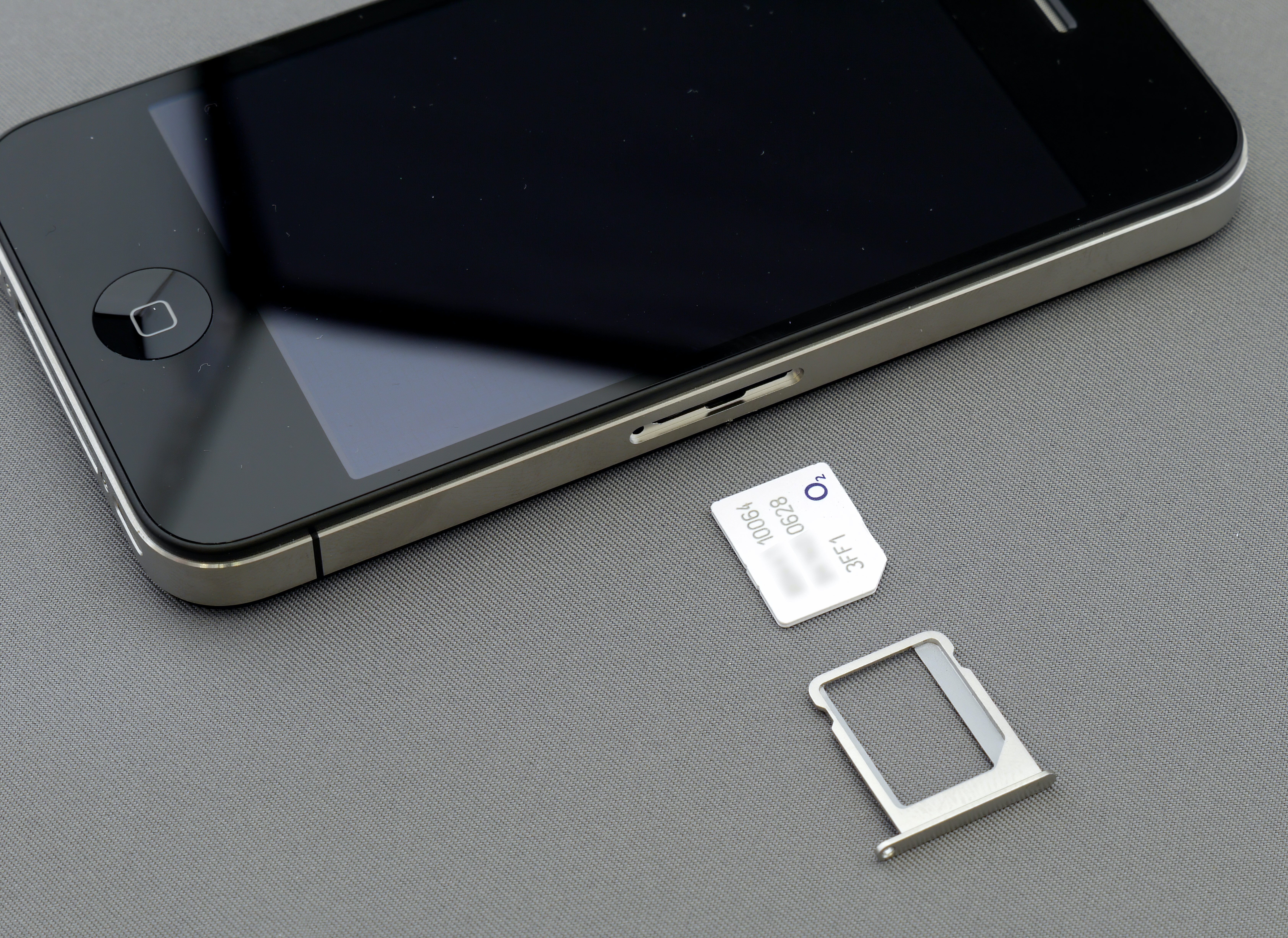 iPhone with SIM card and SIM card holder beside it